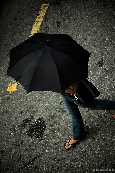 Overhead shot of a girl with umbrella walking in Bukit Bintang, Kuala Lumpur, Malaysia