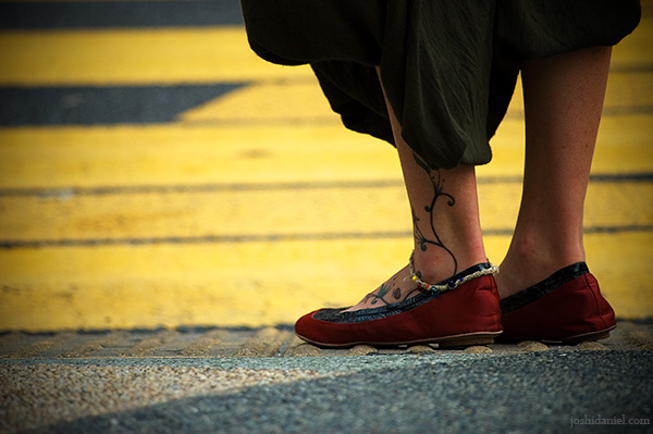 Girl with tattooed leg waiting to cross the road in Bukit Bintang, Kuala Lumpur, Malaysia