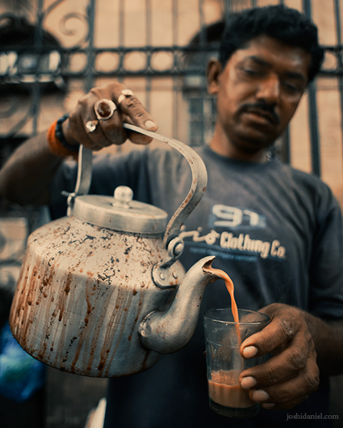 A roadside tea seller in Mumbai serving cutting chai from a kettle