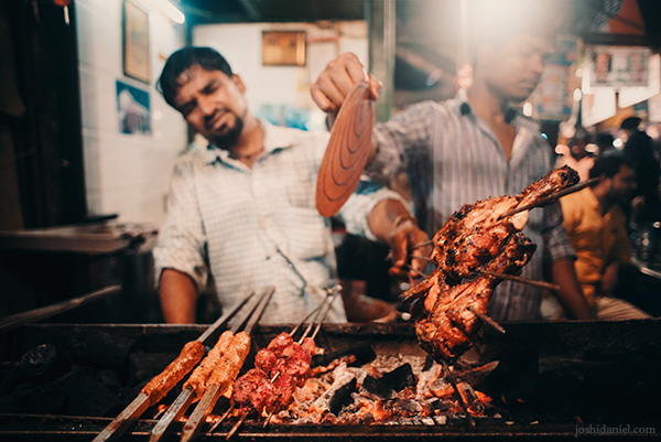 A street food cook grilling meat on Mohammad Ali Road, Mumbai, India